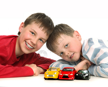 两个男孩在白色背景下打车牌汽男孩们运动的图片