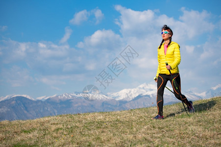 在山上穿黄色外套的女孩漫步在山下赛跑者景观活力图片