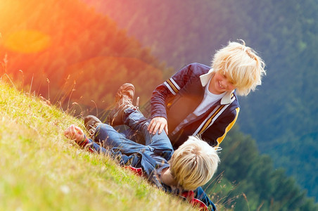 远足夏天有两个金发孩子在山的草地上玩田友谊青年图片