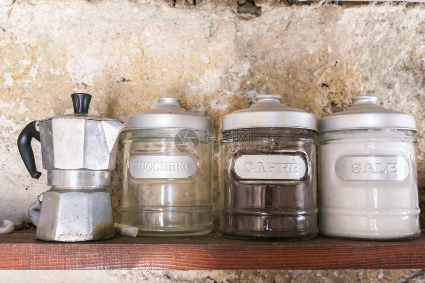 乡村的古老木头架子上装有咖啡糖和盐罐头的旧咖啡壶图片