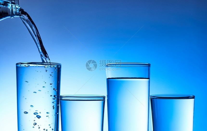 清除将水倒入玻璃中以蓝底为的玻璃杯福利健康图片