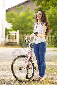 一个美丽的年轻女子骑着自行车绿色夏天假期图片