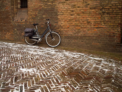 荷兰的主要运输工具是单自行车在海牙的冬季一天靠在办公大院的墙壁站起一堵自行车是荷兰的主要交通工具之一双车建造拉根庭院背景图片