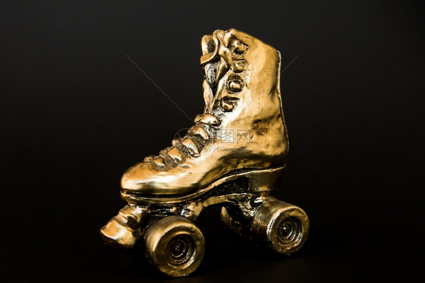 古董运动在黑色背景下隔离的高跟鞋金色滚滑溜冰锻炼图片