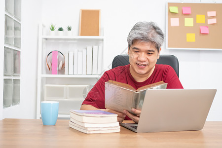 快乐的人类放松点亚洲老人在读书和家办公室听音乐时放松教育图片