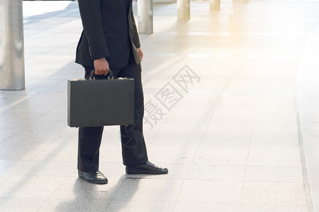 商人在大城市里拉一个袋子套装种行政人员图片
