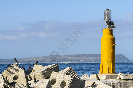 海洋支撑非洲的黄色灯塔和冲浪断流器导航图片