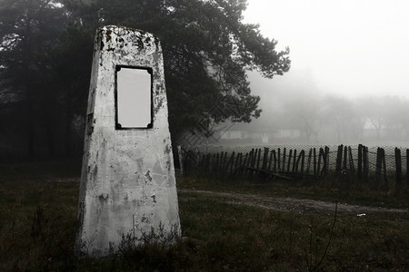 墓石早晨埋没雾中道路附近的一块墓碑图片