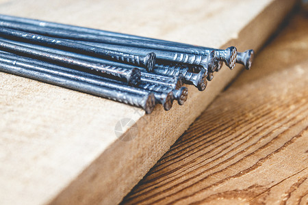 桌子木工板背景上带钉子的旧锤建筑工程具特写板子背景上带钉的旧锤工作图片