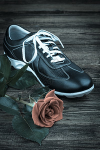 蕾丝黑芒高鞋和木制玫瑰背景野生的时尚图片