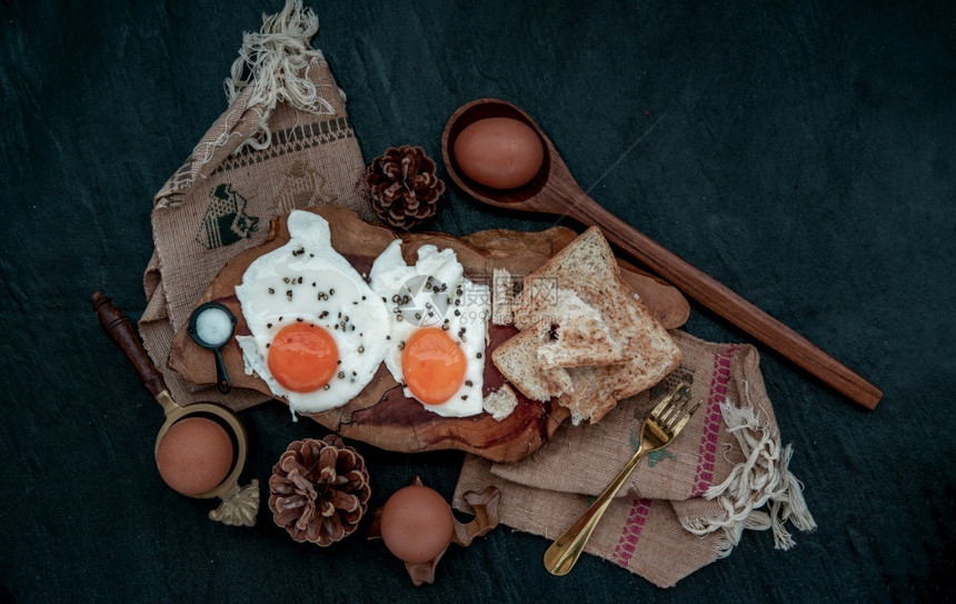 食物美两个炸鸡蛋和烤面包健康早餐的面包在美丽木背景上营养概念从顶部看蛋壳图片