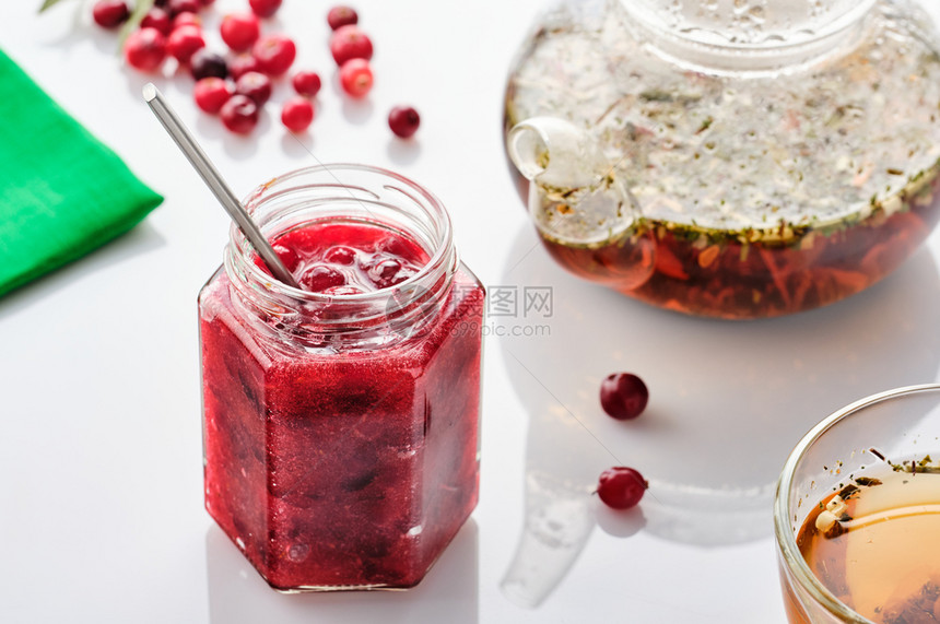 红色的浆果食物白背景的玻璃罐子和茶壶中的干莓果酱图片