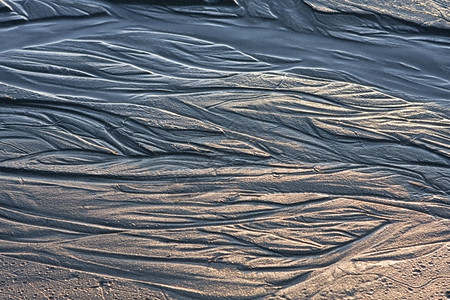 沙滩床拉根在沙滩上流过小溪的细预丸路径与大三角河的条纹通道相似阴暗和亮光是突出的因为图像是在太阳非常低的时候拍摄掌声树荫和亮点之所以显设计图片