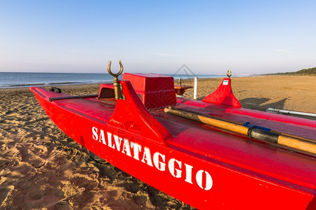 日落旅游海滩上的救生船在背景的海面上支撑图片