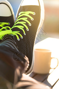 鞋履上新人们在日落时休息他的双脚躺在桌子上新的跑步优质背景