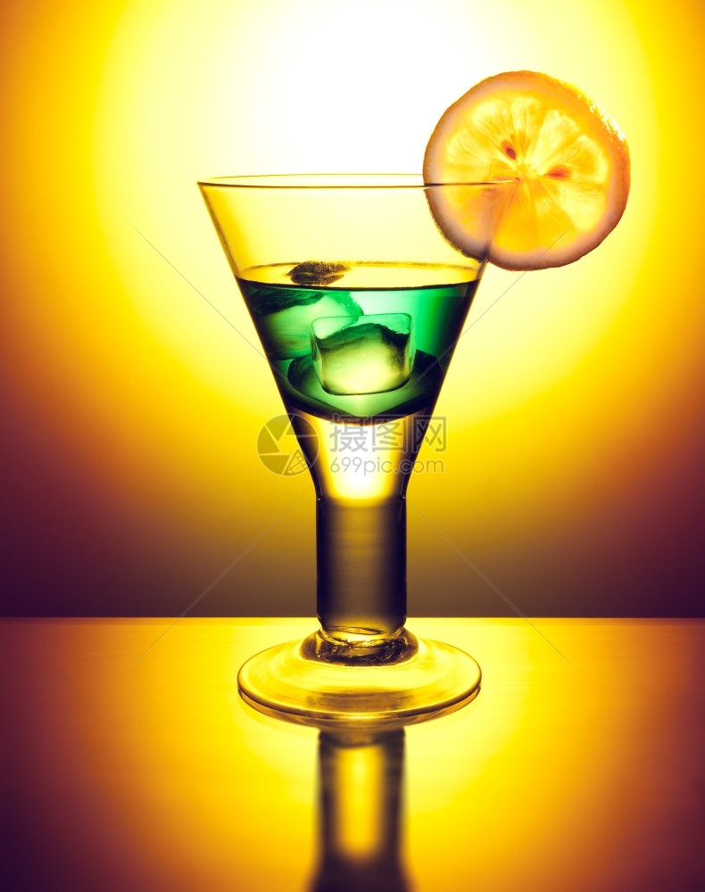酒吧喜悦力量绿色鸡尾酒加装饰的冰和橙色背景柠檬片图片