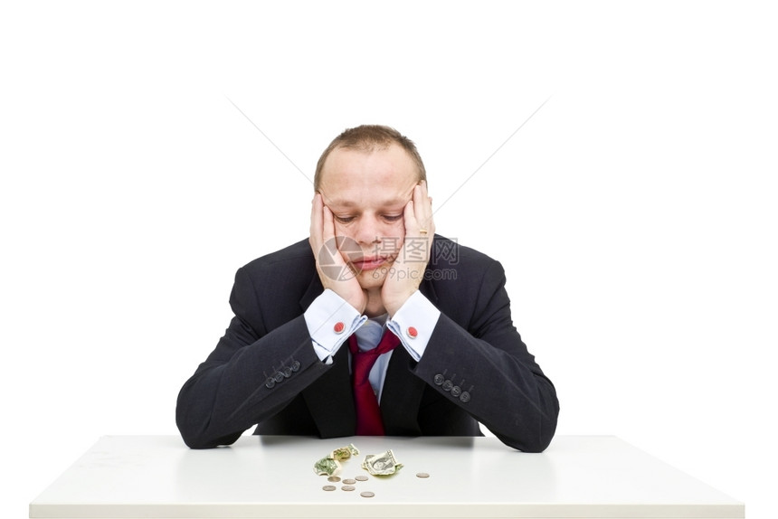 经济衰退一位绝望的商人带着一个未扣锁领和松开的纳克提人沮丧地看着桌子上他面前的几美元这说明经济形势不佳AC54970第16页危机图片
