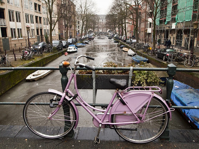 自行车锁街道水冰一辆粉红色的自行车被锁在阿姆斯特丹运河上一座桥的栏杆自行车是荷兰的主要交通工具背景