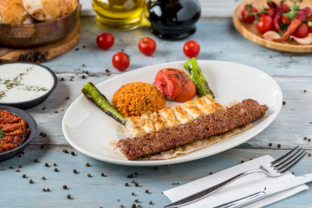 乌尔法肉剁碎土耳其人AdanaKebab配有牌子上的蔬菜图片