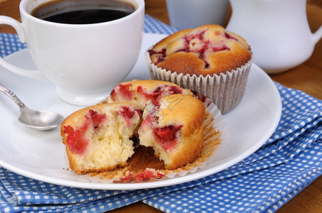 烘烤的饼干松和草莓在一桌咖啡杯上甜味图片