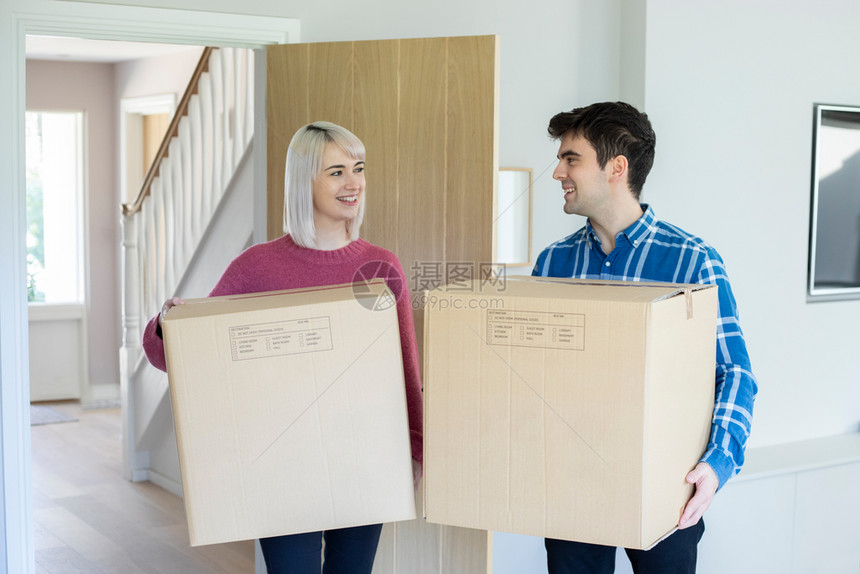 抵押移动盒子年轻夫妇在搬家日携带箱子进新家图片