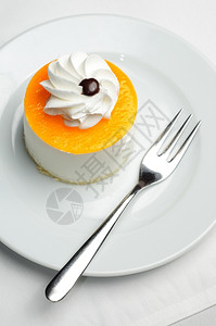 白色的盘子上小圆橙味蛋糕芝士新鲜的星光图片