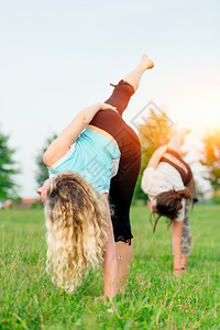 正在做训练冥想两个在户外做瑜伽锻炼的年轻妇女图片