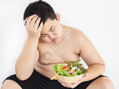 一种个胖男孩讨厌吃蔬菜沙拉亚洲人不开心图片