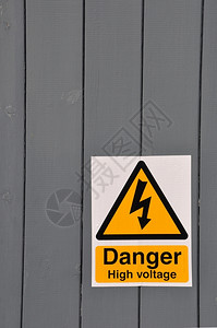 禁止震惊行业木板背景上的黄色标志高电压危险图片