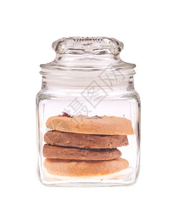 可口坚果透明玻璃罐中的饼干在白色背景上被孤立小麦图片