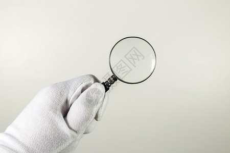 灰色背景上的白手套装有放大镜抽象的征证据高清图片