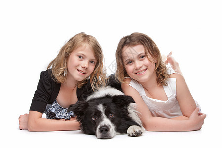 团体两个女孩和一只狗两女孩和一只狗躺在前面的一条狗工作室纯种图片