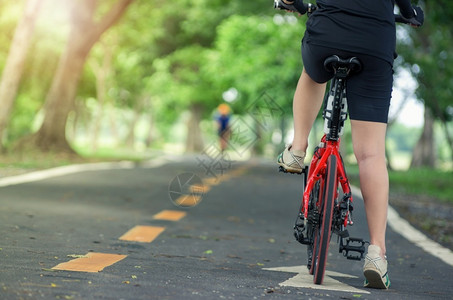 在亚洲女自行车手的背后戴着套的放在自行车女手的把上活动积极的优质图片