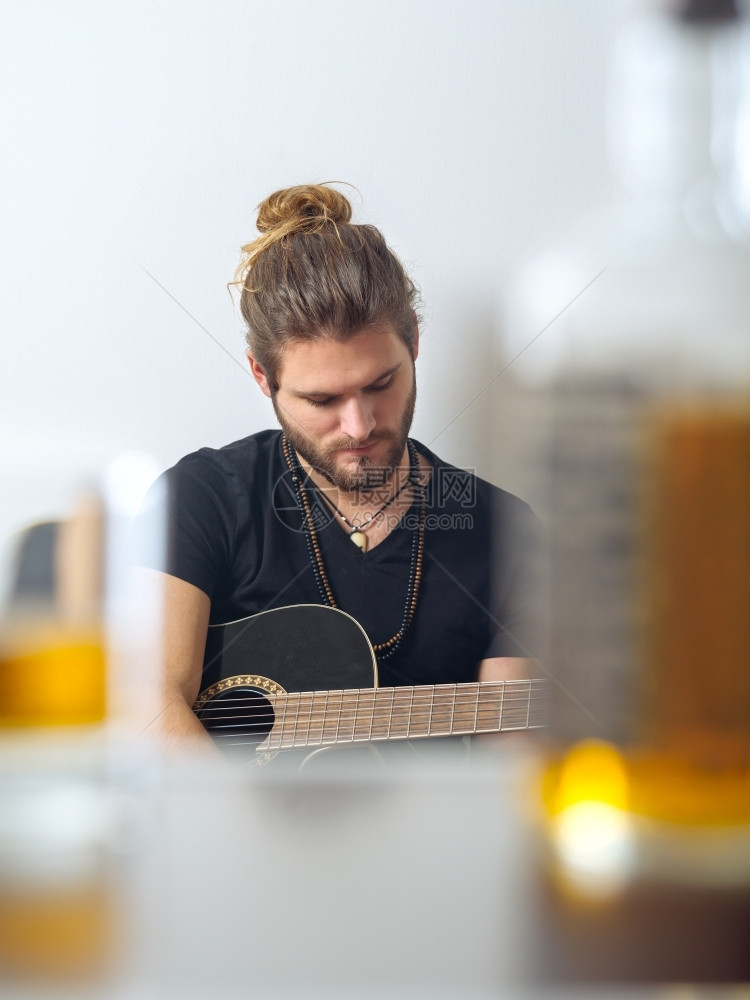 照片来自一位男作曲家配有音响吉他在模糊的威士忌瓶子和岩石杯之间拍摄闲暇音乐萨姆纳斯图片