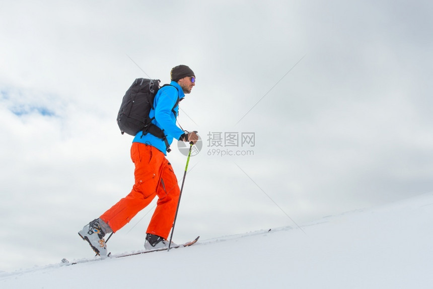 征服独自一个人滑雪的登山者爬上高峰会最佳叉图片
