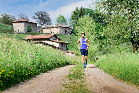 景观赛跑者年轻的青运动员在农村山丘地貌图片