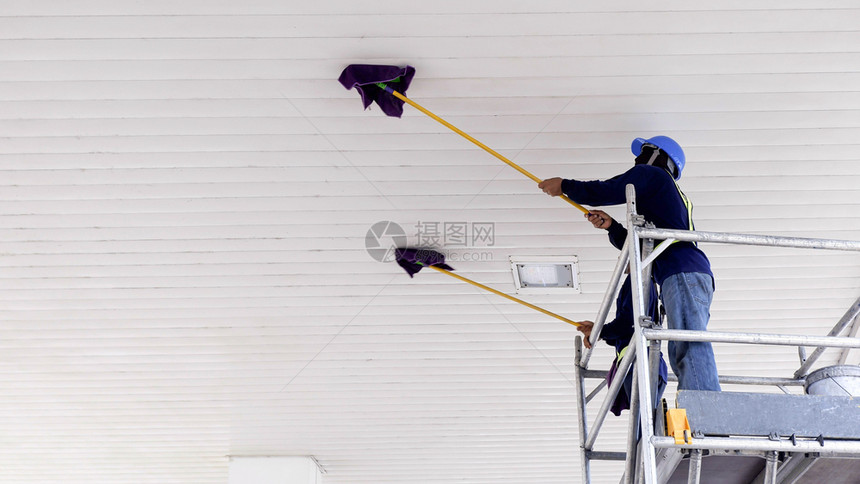选择地重点关注2名工人使用平式湿拖把来擦清加油站的白色天花板占领概念低角度视图复制空间脚架金属职业难的图片