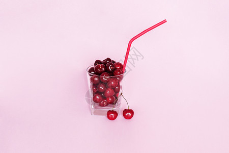 喝粉红色背景概念尝夏天的滋味然新鲜的榨果汁甜樱桃和鸡尾草浆果自然图片