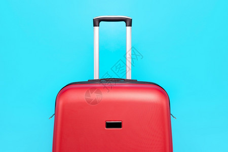 红色旅行李箱在蓝色背景上关闭配件目的飞机场图片