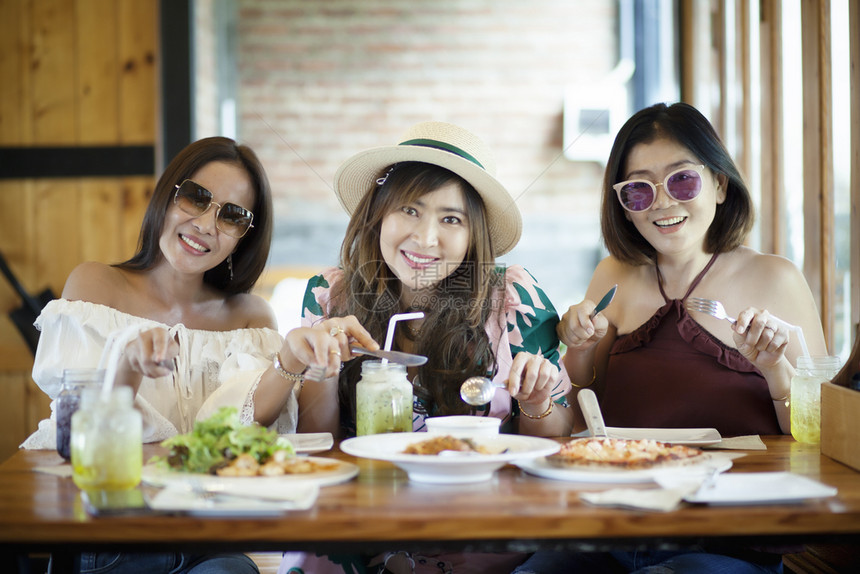 准备好美食午餐三位亚洲女准备在桌上吃西餐图片