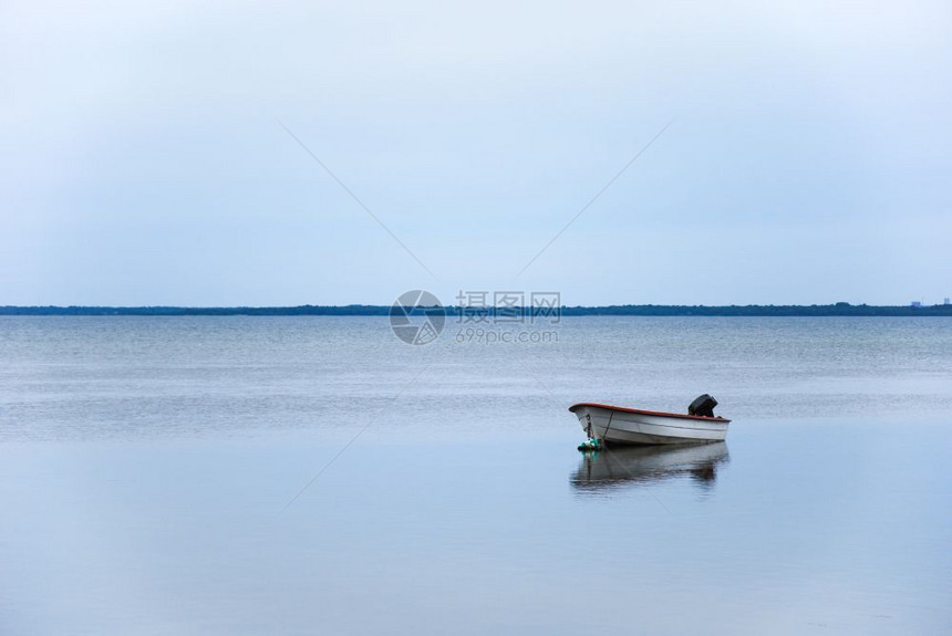 蓝色的海单小船在平静的水中反射湖图片