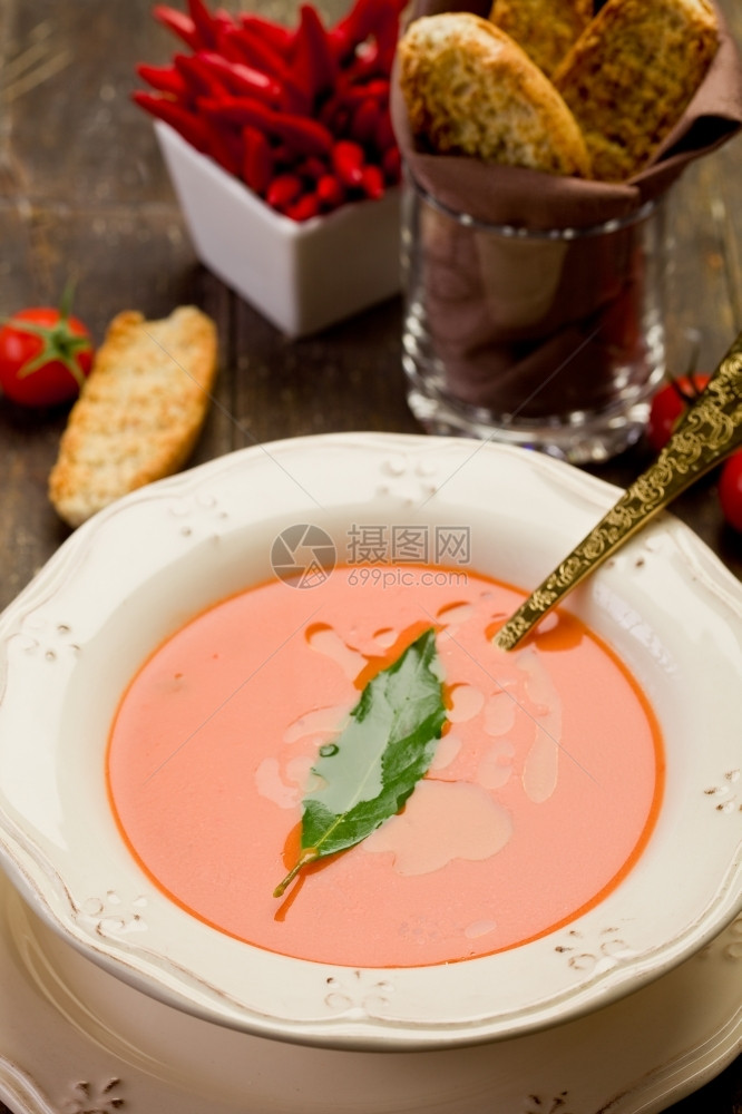 晚餐新鲜自家做的番茄汤木制桌上有叶滴油炸面包块图片