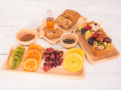 葡萄干假期一份水果蛋糕和干面包配有蜂蜜薄粉木板中的肉桂和白底碗晒干图片