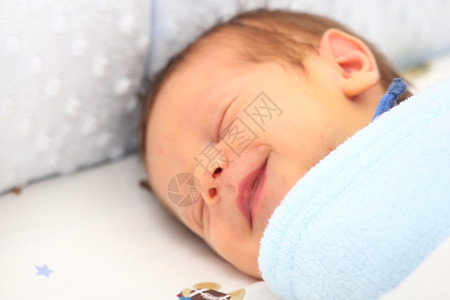 睡眠有趣的覆盖新生儿微笑的毯子盖着一个新生儿的毯子焦点在毯子里幸福图片