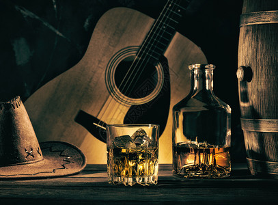 面对吉他背景的牛仔死对抗吉他背景的牛仔死皮革高脚杯威士忌酒图片