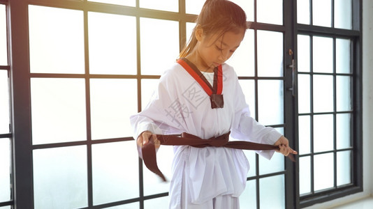 柔术战斗机年轻的亚洲女孩在演播室结了一条黑带制服武术背景