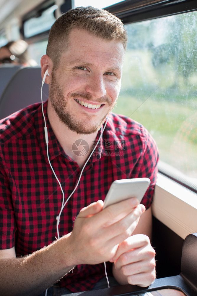 年轻人在工作旅程中通过移动电话聆听音乐的青年之旅运输连接的图片