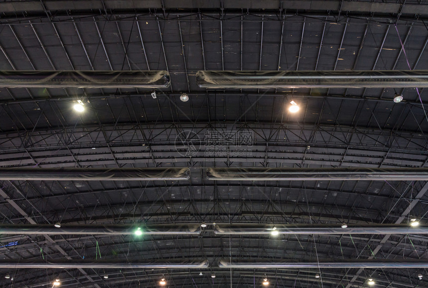 复杂的金属框架展厅天花板上有灯泡笼明亮的力量聚光灯图片