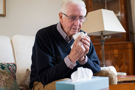 吹高级的八十年代在家中受寒冷或流感折磨的老人背景图片