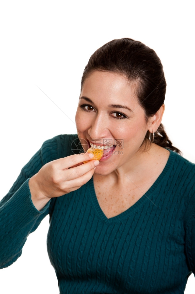 美味的黑发丽快乐女人吃着一小片满维他命C的红橘子果以健康饮食孤立无援绿色图片